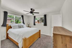 Bedroom featuring light colored carpet, baseboards, and ceiling fan