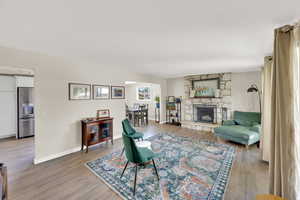 Living area with light wood finished floors, baseboards, and a fireplace