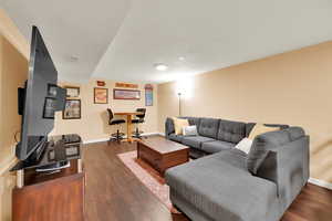 Living room with baseboards, wood finished floors, and a textured ceiling