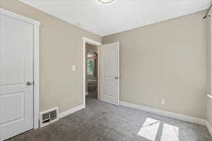Unfurnished bedroom featuring carpet, baseboards, and arched walkways