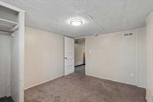 Unfurnished bedroom with carpet floors and wood walls