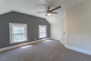 Bonus room featuring a ceiling fan, healthy amount of natural light, vaulted ceiling, carpet, and baseboards