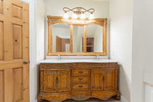 Full bath featuring double vanity and baseboards