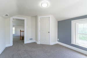 Bonus room featuring lofted ceiling, carpet floors, and baseboards
