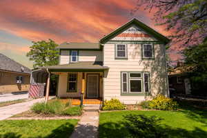 Victorian home with covered porch, a carport, and driveway