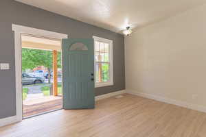 Entryway with baseboards and light wood-style flooring