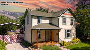 View of front of home featuring roof with shingles, covered porch, a chimney, a mountain view, and a carport