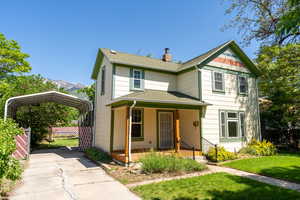 Victorian home featuring a carport, a porch, a shingled roof, a chimney, and a mountain view