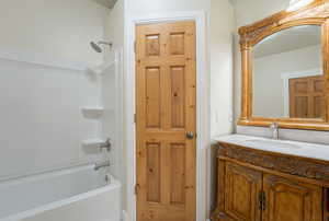 Bathroom featuring vanity and washtub / shower combination