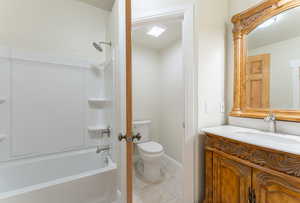 Bathroom featuring vanity, toilet, and washtub / shower combination