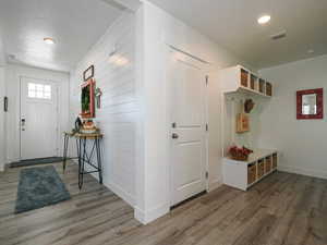 Mudroom with wood finished floors, baseboards, recessed lighting, and a textured ceiling