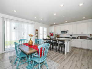 Dining space with light wood-style floors and recessed lighting
