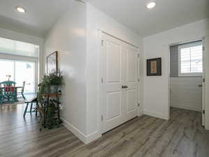 Corridor featuring wood finished floors, plenty of natural light, baseboards, and recessed lighting