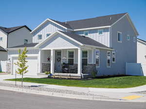 View of front of home with covered porch, board and batten siding, a garage, driveway, and roof with shingles