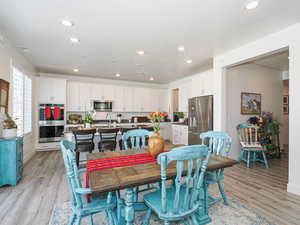 Dining room with light wood finished floors, recessed lighting, and baseboards