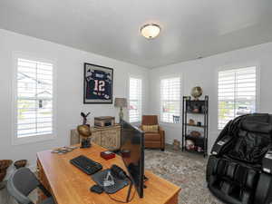 Office space with wood finished floors, baseboards, and a textured ceiling