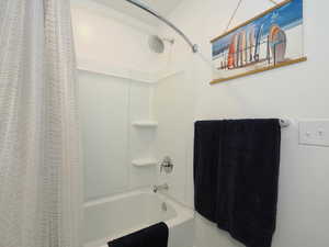 Full bath featuring shower / tub combo adjacent to guest bedroom