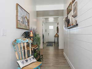 Corridor featuring shiplap and wood finished floors
