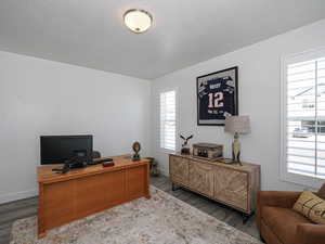 Office area with wood finished floors, baseboards, and a textured ceiling