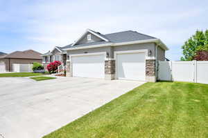 View of front of house featuring stone siding, concrete driveway, a garage, stucco siding, and a shingled roof