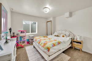 Bedroom featuring light carpet and baseboards