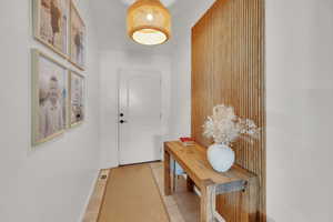 Doorway with baseboards and light wood-type flooring