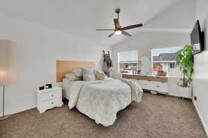 Bedroom with light carpet, lofted ceiling, baseboards, and ceiling fan