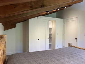 Unfurnished bedroom with track lighting and carpet