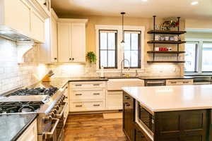 Kitchen featuring stainless steel appliances, a sink, recessed lighting, dark stone counters, and decorative backsplash