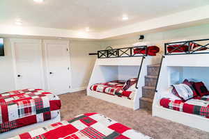 Carpeted bedroom featuring a textured ceiling and recessed lighting