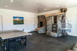 Playroom featuring recessed lighting, baseboards, a textured ceiling, and a fireplace