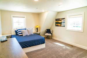 Carpeted bedroom featuring a textured ceiling, baseboards, and recessed lighting