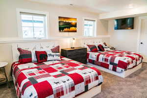 Carpeted bedroom featuring multiple windows