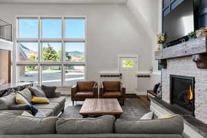 Living room featuring a high ceiling, a fireplace, and dark wood finished floors