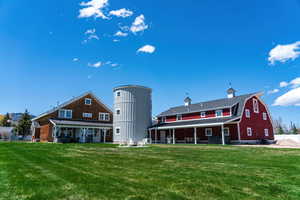 Back of property with a barn, a lawn, and metal roof