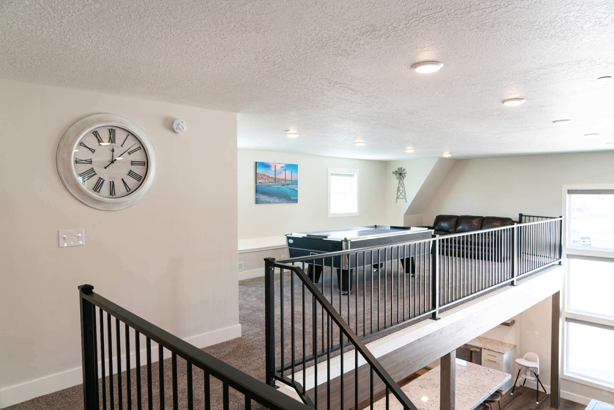 Hall featuring an upstairs landing, baseboards, a textured ceiling, and carpet flooring