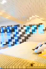 Unfurnished bedroom featuring recessed lighting, wooden walls, carpet, and wooden ceiling