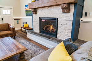 Living area featuring wood finished floors, baseboards, and a fireplace
