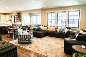 Living room with wood-type flooring, healthy amount of natural light, and recessed lighting
