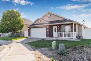 View of front of house featuring a porch, concrete driveway, an attached garage, brick siding, and a shingled roof