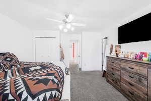 Carpeted bedroom with a closet and ceiling fan