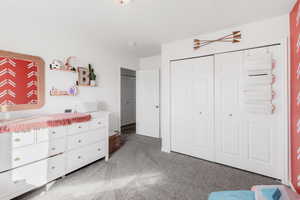 Bedroom featuring light carpet and a closet