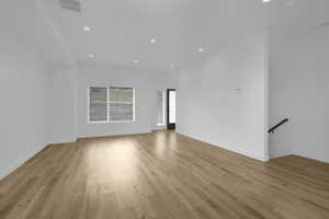 Unfurnished living room featuring recessed lighting, light wood-style flooring, and baseboards