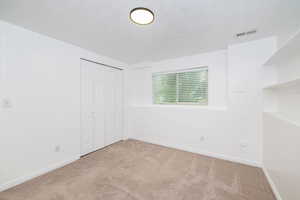 Unfurnished bedroom with carpet floors, baseboards, and a closet