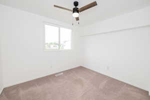 Unfurnished room with carpet, a ceiling fan, and baseboards