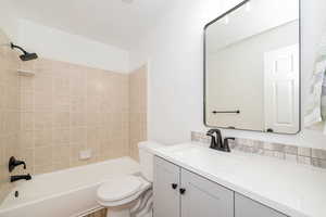 Full bathroom with toilet, vanity, and  shower combination