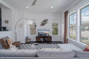 Living area with wood finished floors, ceiling fan, baseboards, and recessed lighting