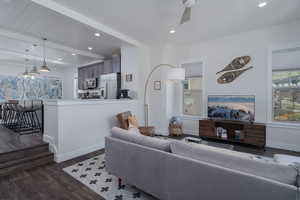 Living area with dark wood-style flooring, baseboards, beamed ceiling, recessed lighting, and ceiling fan