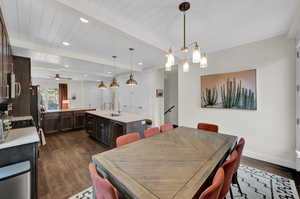 Dining room with dark wood-type flooring, baseboards, recessed lighting, wood ceiling with exposed beams, and ceiling fan