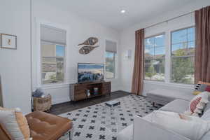 Living room featuring plenty of natural light, baseboards, recessed lighting, and wood finished floors